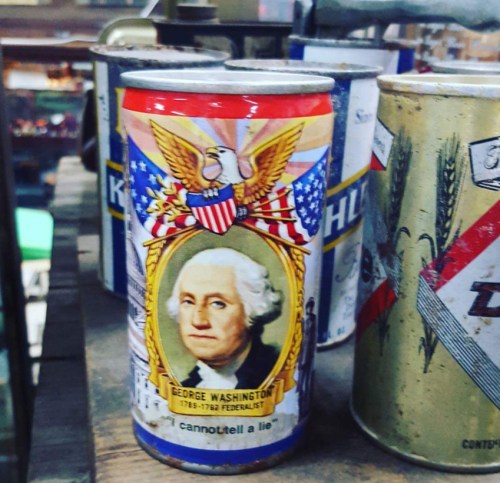 Vintage can featuring George Washington's portrait, surrounded by patriotic symbols and the phrase "I cannot tell a lie."