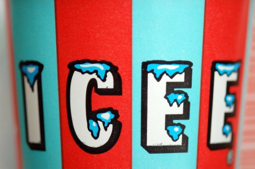 Close-up of an Icee cup featuring red and blue stripes with the word "ICEE" in bold, icy letters.