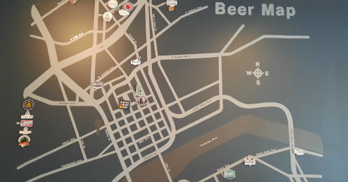 A wall-mounted beer map featuring various breweries and locations marked in a city layout.