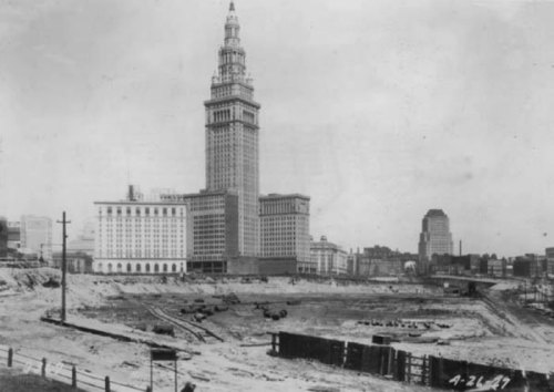 Historic black-and-white photo of a cityscape featuring a tall tower and construction site, dated April 21, 1947.