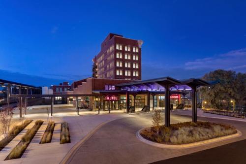 Modern hotel building at dusk, featuring a welcoming entrance and landscaped surroundings.