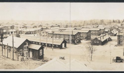 Aerial view of a historic neighborhood with rows of houses and streets, captured in sepia tones.