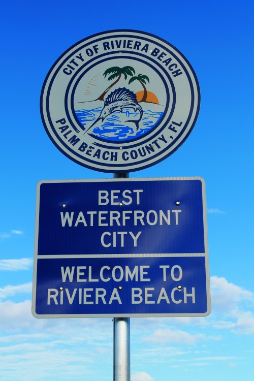 Sign for Riviera Beach, Florida, highlighting it as the "Best Waterfront City" with a blue sky backdrop.