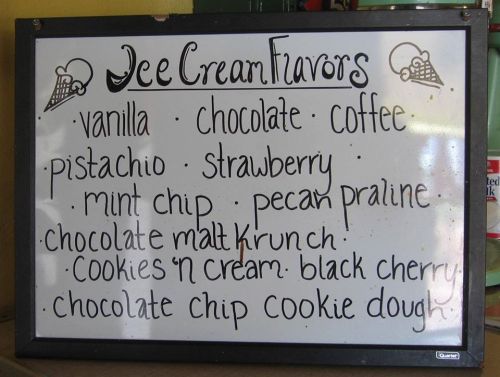 A chalkboard menu listing various ice cream flavors: vanilla, chocolate, coffee, pistachio, strawberry, and more.