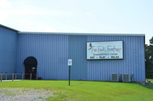 Exterior of The Funky Feather Entertainment Center, featuring a blue building with a sign that says "Eat, Play, Relax."