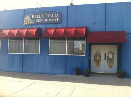 Exterior of Bella Italia Restaurant, featuring a blue building, red awnings, and double doors.