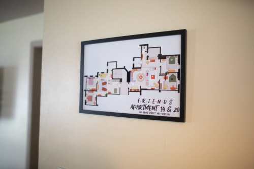 Framed floor plan of the Friends TV show apartments 19 and 20, displayed on a wall.