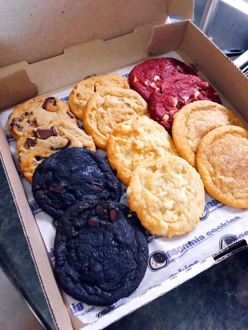 A box of assorted cookies, including chocolate chip, red velvet, and white chocolate macadamia, neatly arranged.