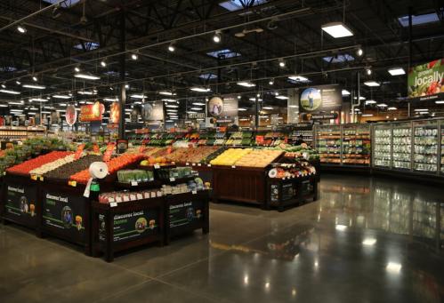 A spacious grocery store interior featuring colorful produce displays and well-organized shelves.