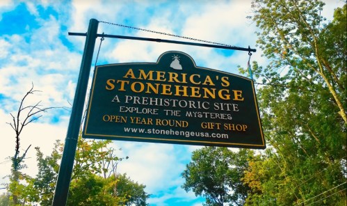 Sign for America's Stonehenge, a prehistoric site, inviting visitors to explore and visit the gift shop. Open year-round.
