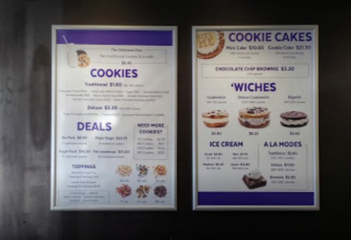 Menu board featuring cookies, cookie cakes, deals, and ice cream options with prices listed.