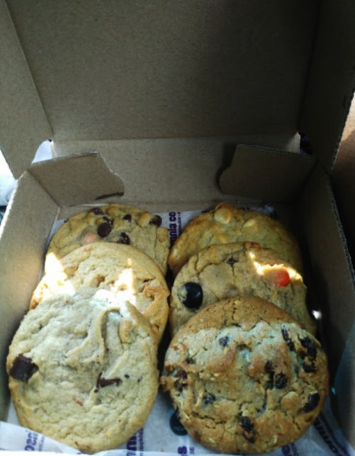 A box of assorted cookies, including chocolate chip and oatmeal, arranged neatly inside.