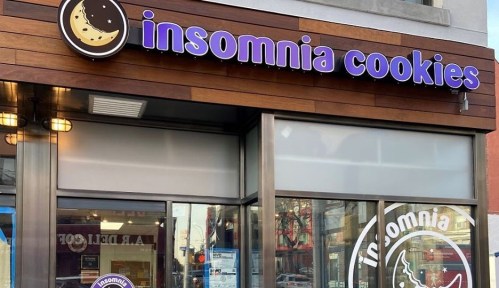 Signage for Insomnia Cookies, featuring a cookie logo and a modern storefront with large windows.