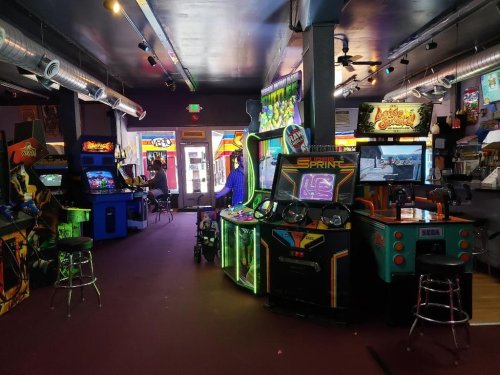 A vibrant arcade filled with classic video game machines and colorful decor, inviting players to enjoy retro gaming.