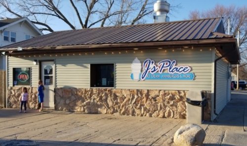A small ice cream shop with a sign reading "J's Place," featuring children outside and a welcoming atmosphere.