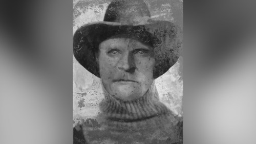 A vintage black-and-white portrait of a stern-looking person wearing a wide-brimmed hat and a turtleneck sweater.