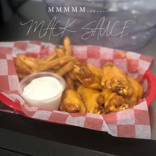 A red basket filled with chicken wings, fries, and a side of dipping sauce, with a decorative text overlay.