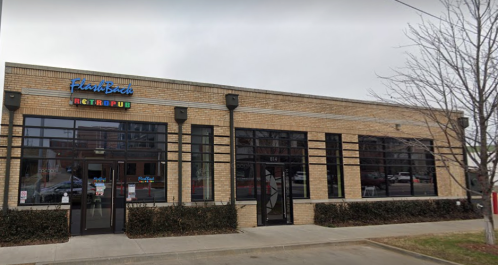 Exterior of a brick building with large windows, featuring a sign that reads "Flint's Back Retro Pub."