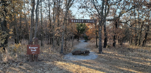 A path marked "Ranger Trail" leads through a wooded area with autumn foliage and a signpost.
