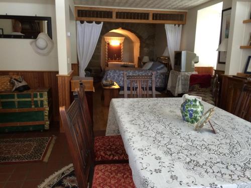 Cozy interior featuring a dining table, vintage decor, and a glimpse of a bedroom with a stone archway.