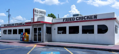 Exterior of Old South Restaurant featuring a sign for fried chicken and a retro design with large windows.