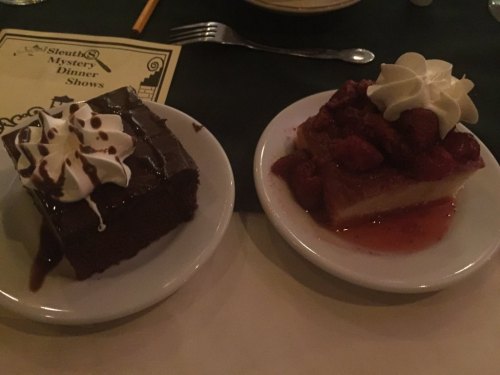 Two dessert plates: one with chocolate cake topped with whipped cream, the other with cheesecake and strawberry sauce.