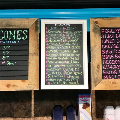 A chalkboard menu displaying various ice cream flavors, including chocolate, vanilla, and unique options like cookie dough.