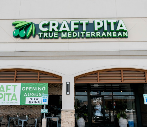 Sign for "Craft Pita True Mediterranean" with a banner announcing the opening and hiring in August.