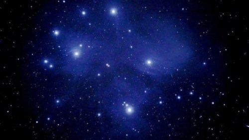 A deep space scene filled with bright stars against a dark, cosmic background.