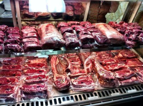 A display of various cuts of meat, neatly packaged and arranged in a refrigerated case.