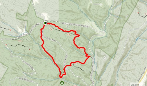Map showing a hiking trail marked in red, winding through a mountainous area with contour lines and road names.
