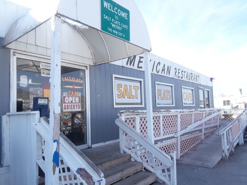 Exterior of Salt Flats Cafe, a Mexican restaurant, featuring a welcoming sign and open doors.
