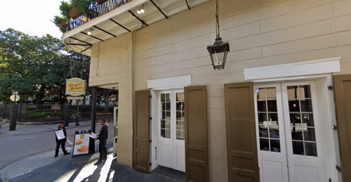 Exterior view of a restaurant with open windows, a lantern, and a sign reading "Royal House" in a sunny street.