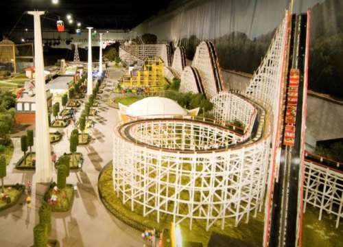 A detailed model of a theme park featuring roller coasters, buildings, and landscaped areas.