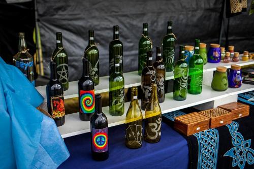 A display of decorative glass bottles and jars in various colors and designs on a table.