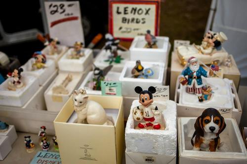 A collection of decorative figurines, including animals and characters, displayed in boxes at a market.
