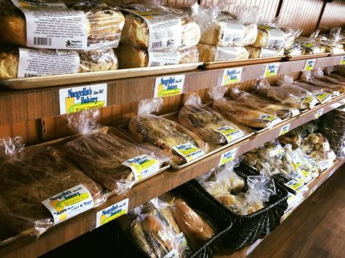 A bakery display featuring various loaves of bread and baked goods neatly arranged on wooden shelves.