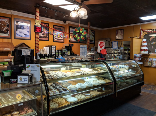 A cozy bakery display filled with various pastries and desserts, featuring glass cases and a warm, inviting atmosphere.