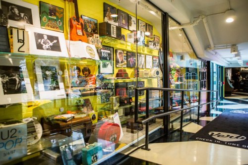 A vibrant display of music memorabilia, including guitars, records, and framed photos, in a colorful hallway.