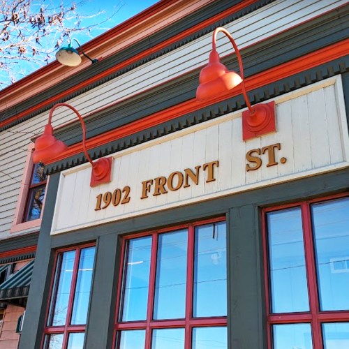 Sign on a building reading "1902 FRONT ST." with decorative light fixtures above it.