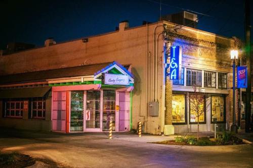 A nighttime view of two buildings, one with colorful lights and signage, showcasing a vibrant urban atmosphere.