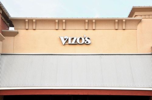 Signage of "Vizo's" on a building exterior with a metal awning below.
