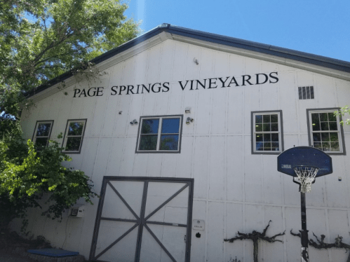 Exterior of Page Springs Vineyards building with windows and a basketball hoop in front.