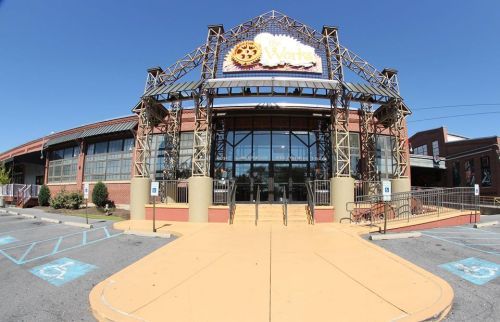 Exterior view of a large building with a distinctive sign, featuring a modern architectural design and clear blue sky.