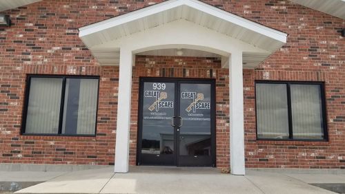 Front entrance of a brick building with large glass doors displaying "Great Escape" signage.