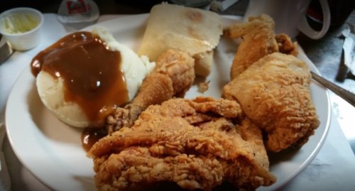 A plate of fried chicken, mashed potatoes with gravy, and a biscuit.