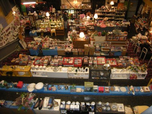 Aerial view of a bustling thrift store filled with various items, including dishes, books, and decorative objects.