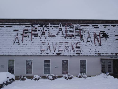 Snow-covered building with "Appalachian Caverns" sign on the roof, surrounded by snow and winter scenery.