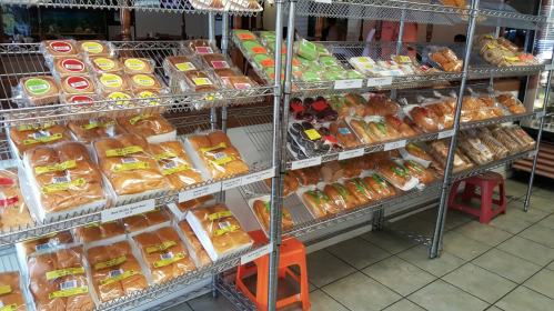Shelves filled with various packaged baked goods and snacks, neatly arranged in a store setting.