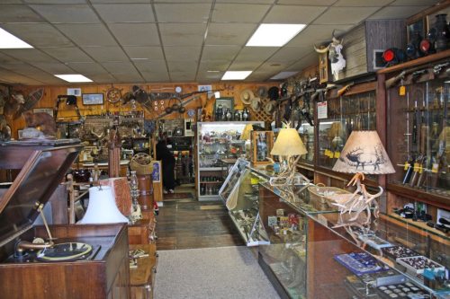 A vintage shop filled with antiques, collectibles, and various items displayed in glass cases and on shelves.